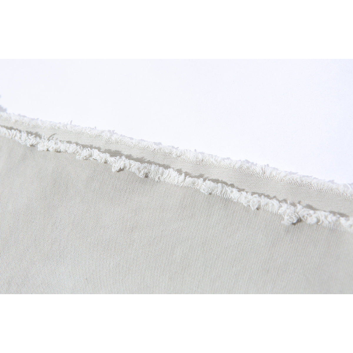 Close-up of light gray fabric with a raw, frayed edge.