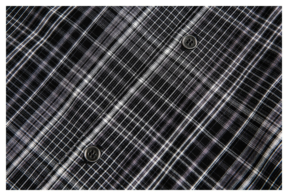 Close-up of black-and-gray plaid fabric with two dark buttons.