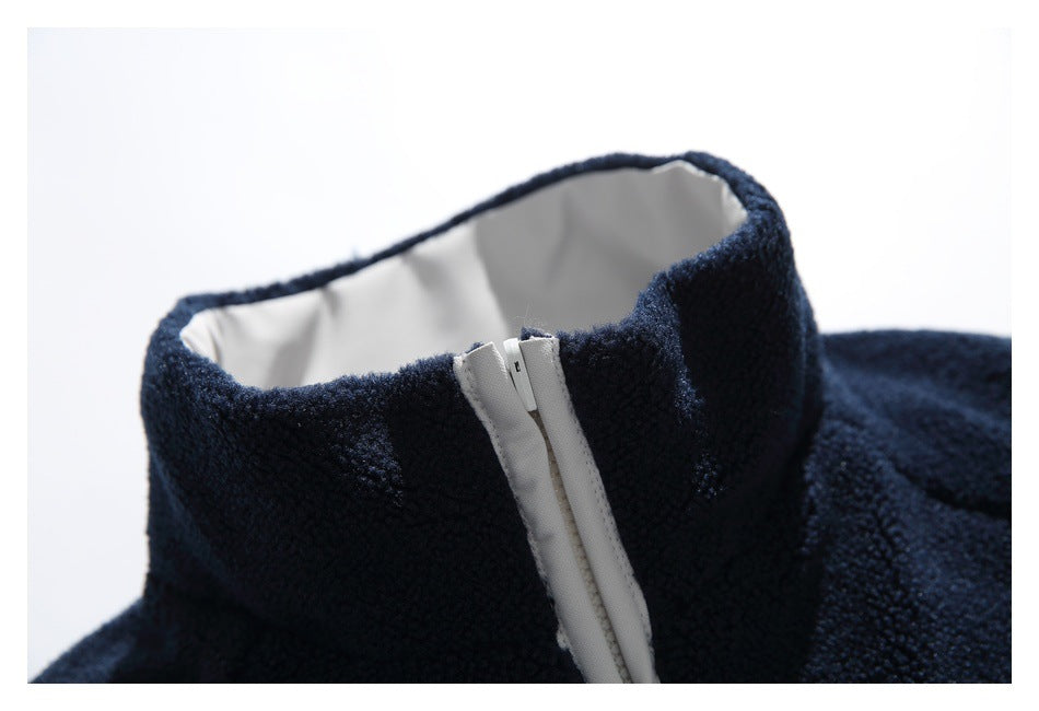 Close-up of a navy fleece jacket collar with white lining and a white front zipper.