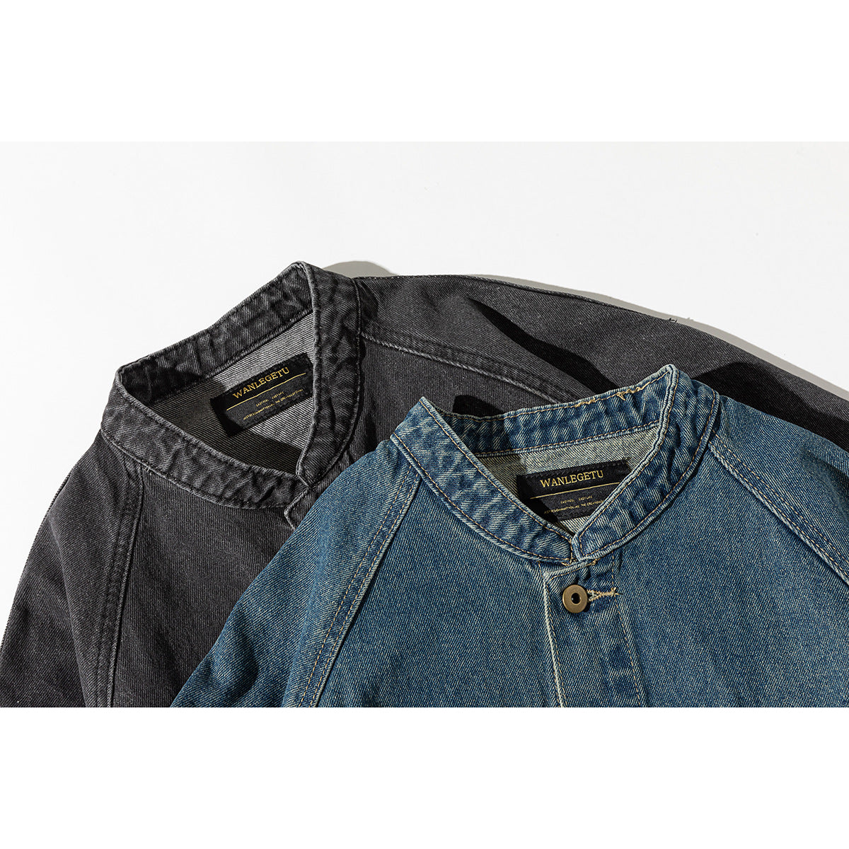 Close-up of blue and charcoal denim jacket collars with button closures and black inner neck labels.