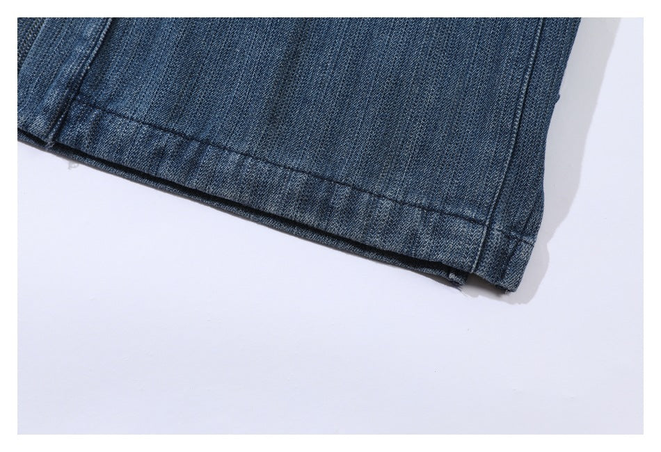 Close-up of the stitched hem on a dark blue denim garment.
