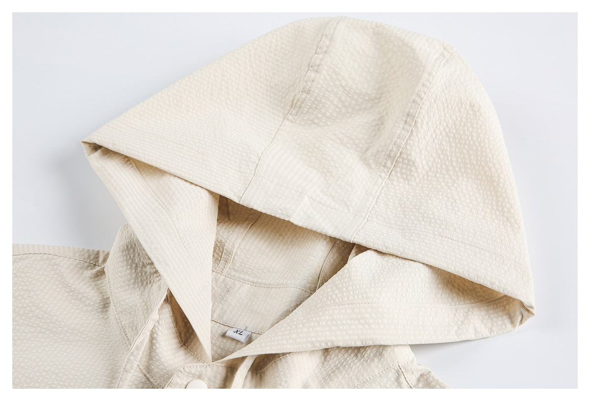 Cream textured hood shown open in close-up, with stitching and part of the snap-front visible.