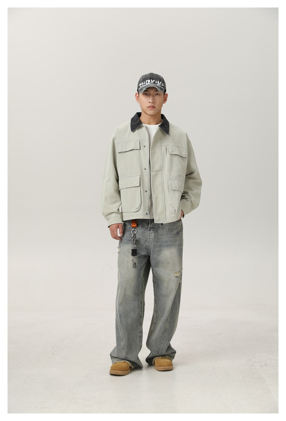 Full-length front view of a model wearing a pale sage utility jacket with a black collar and four flap pockets.
