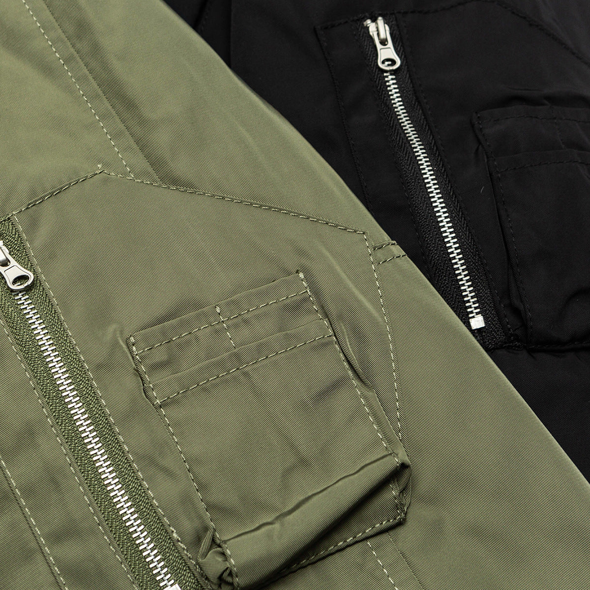 Close-up of olive and black jacket pockets with silver zippers and stitched details.