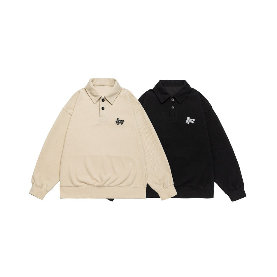 Two flat-lay collared pullovers in beige and black, each with a short button placket and small chest embroidery.