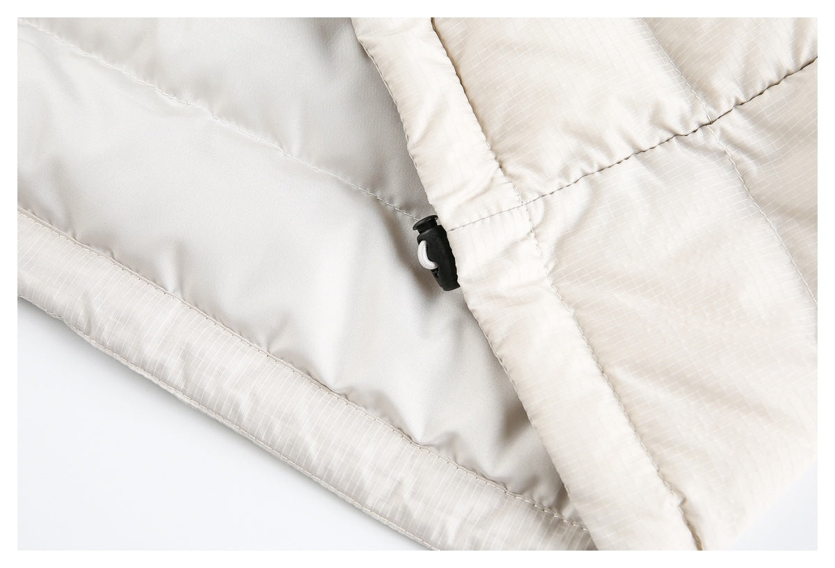 Close-up of the jacket's smooth light-colored lining, quilted outer panels, and black cord toggle.