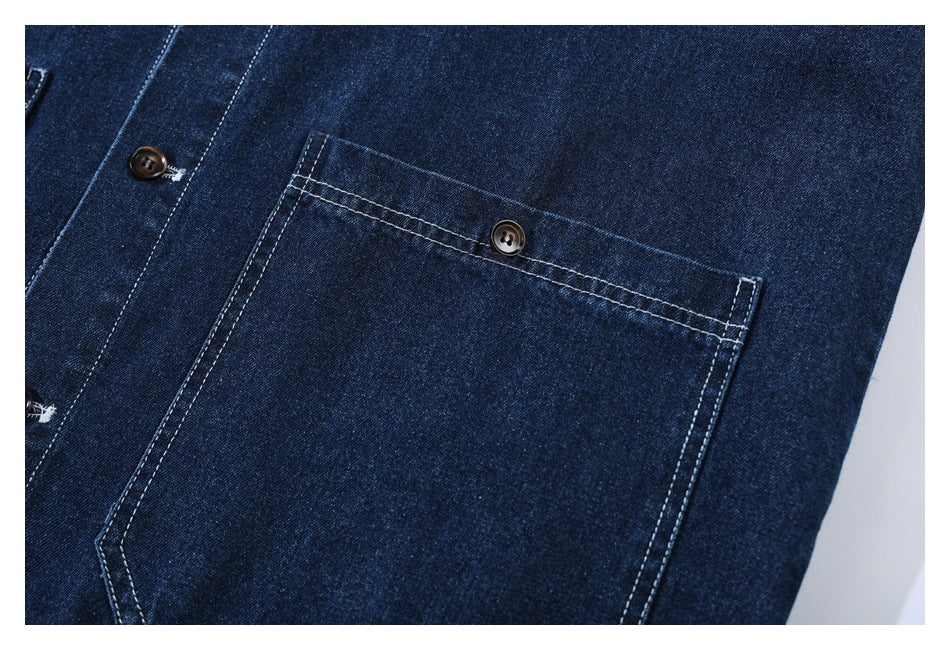 Close-up of a dark indigo denim garment with a buttoned patch pocket and contrasting white stitching.