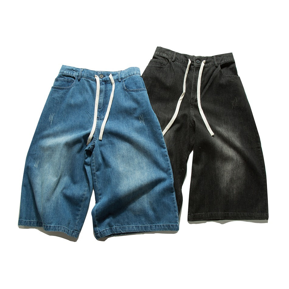 Two pairs of loose denim shorts shown from the front: one blue and one black, both with white drawstrings.