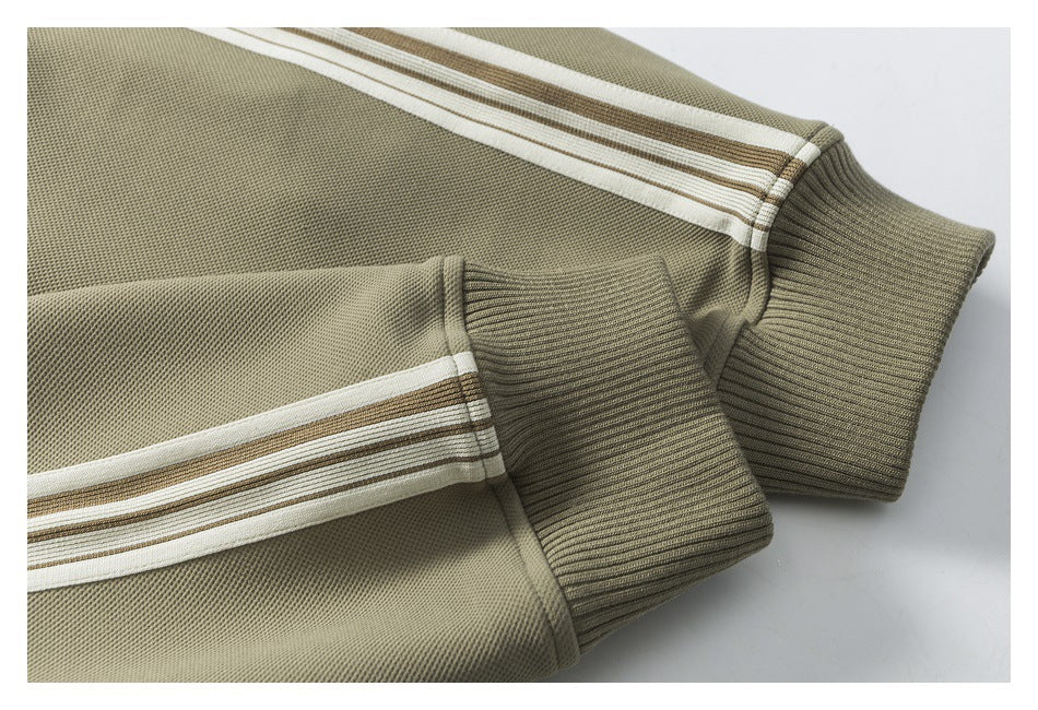 Close-up of an olive sleeve with cream and brown stripes and a ribbed cuff.