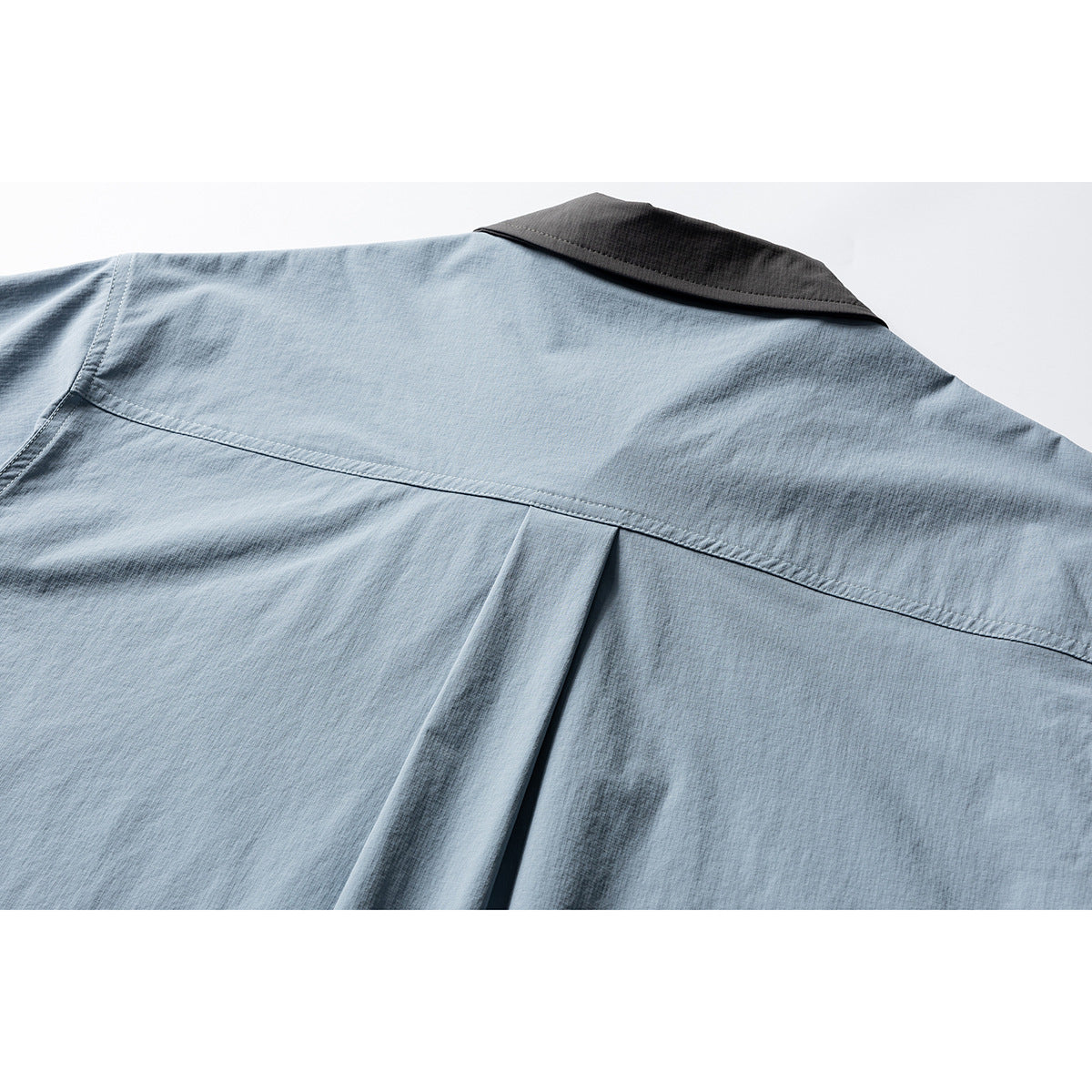 Close-up of the light blue shirt back, showing a charcoal collar, shoulder yoke and center pleat.