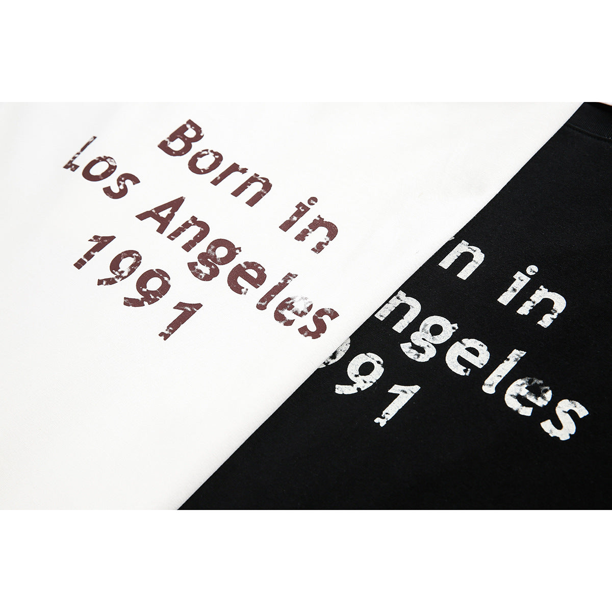 Close-up of distressed “Born in Los Angeles 1991” lettering on white and black T-shirts.
