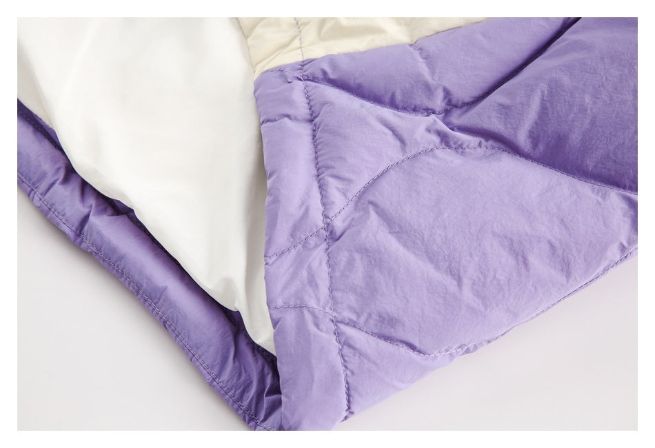 Close-up of lavender quilted fabric with white lining and stitched seams.