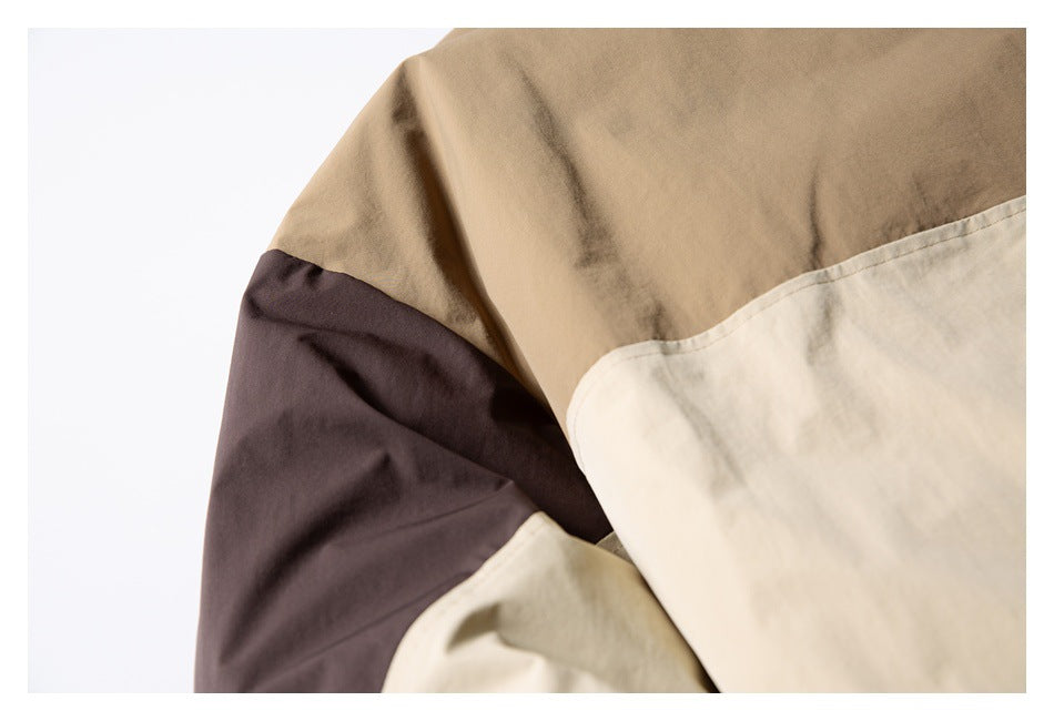 Close-up of tan, dark brown, and cream fabric panels joined by curved seams.