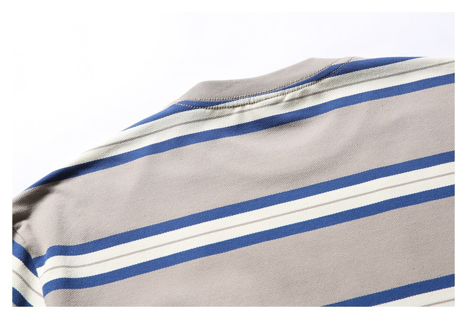 Close-up of a beige-gray striped garment showing the neckline seam and blue-and-white bands.