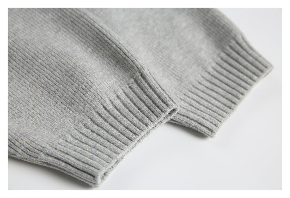 Close-up of light gray ribbed knit garment edges with wide ribbed cuffs or hems.
