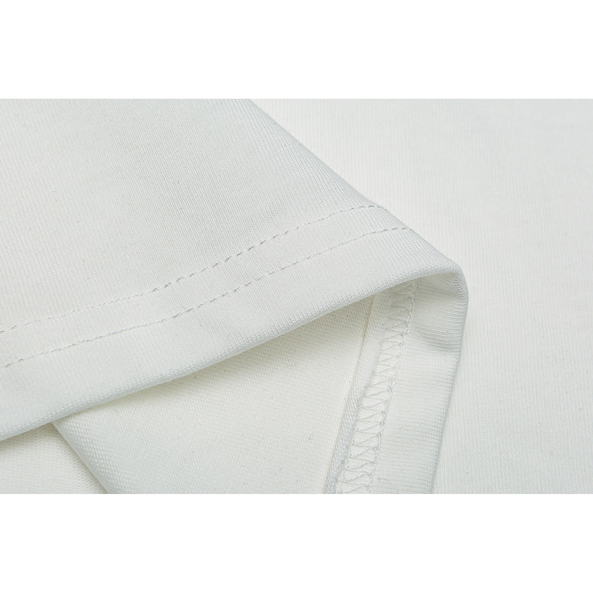 Close-up of the hem and overlocked seam on a white T-shirt.