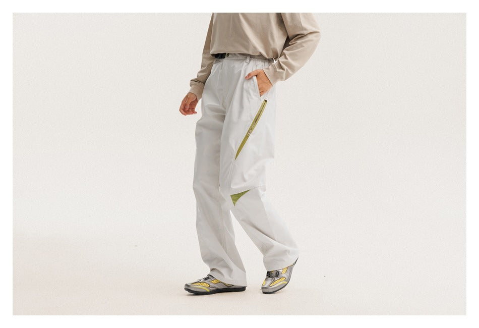 Model wearing loose light gray pants with chartreuse zipper and knee accents, shown from the front.