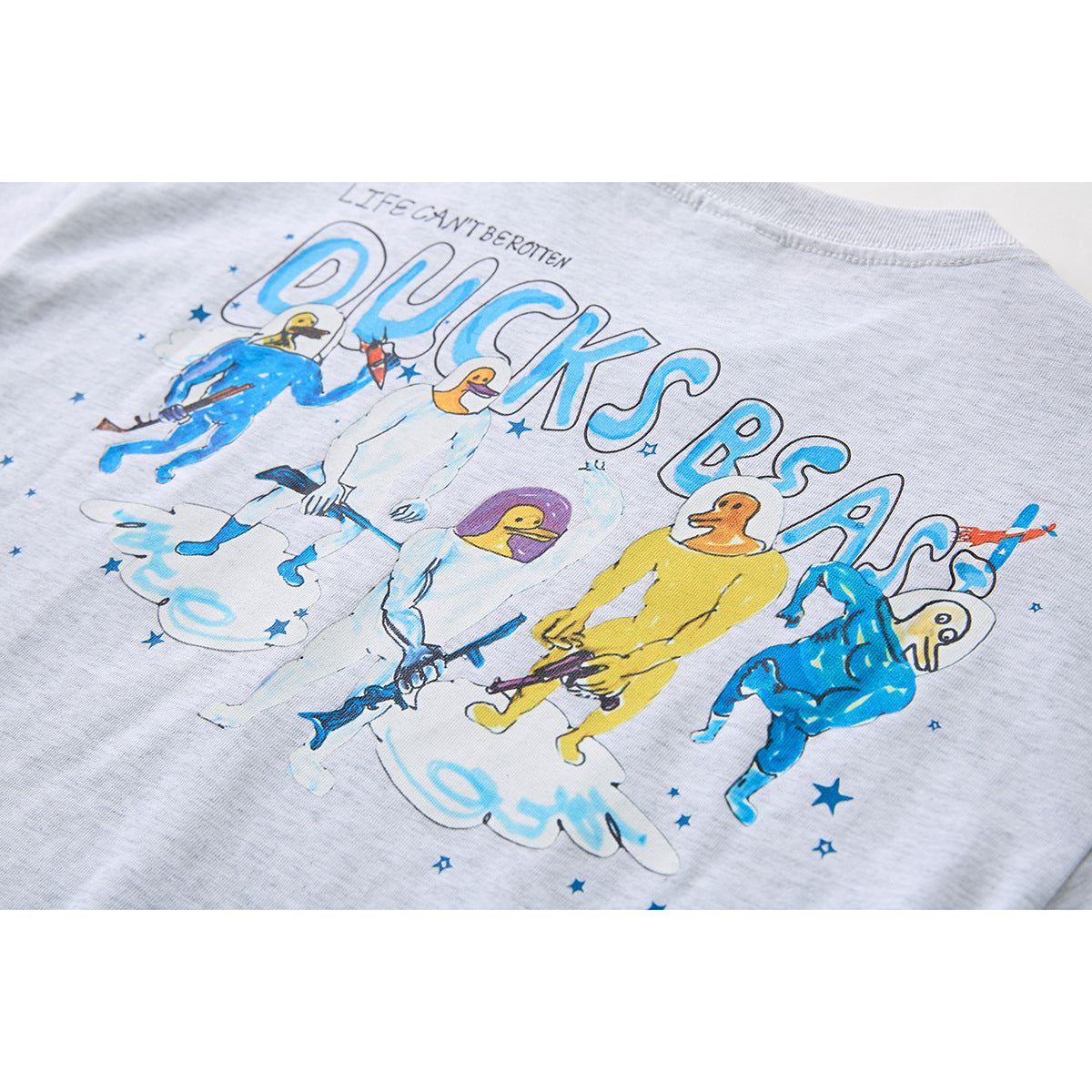 Close-up of a colorful illustrated graphic on the back of a light gray T-shirt.