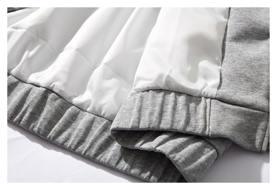 Close-up of white lining above a heather gray ribbed garment hem or cuff.
