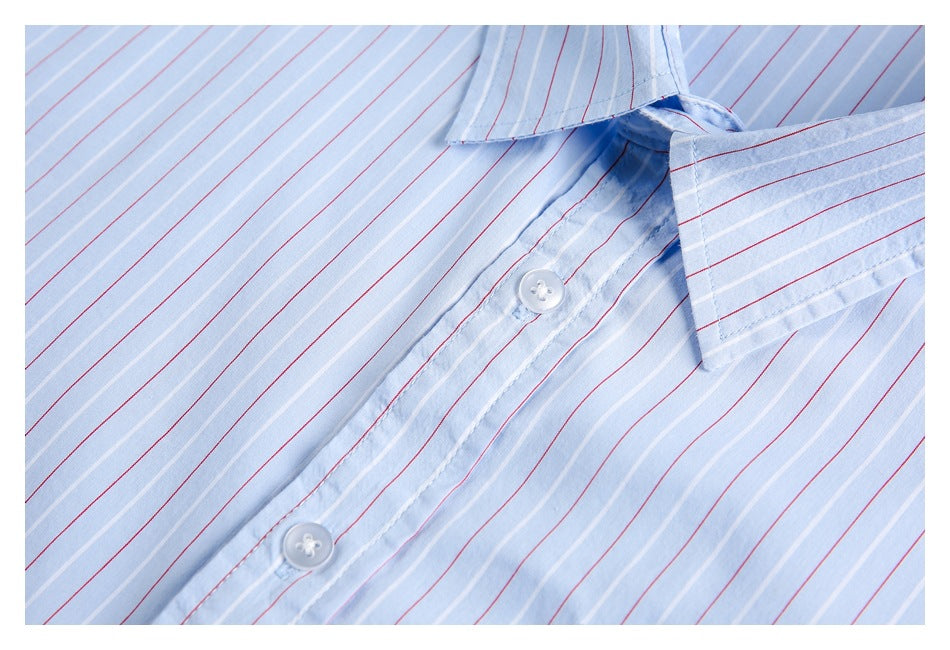 Close-up of the light blue shirt’s striped front placket, white buttons, and collar edge.