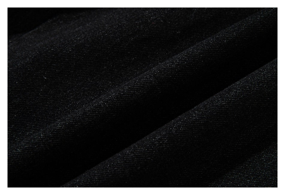 Close-up of black fabric with a fine woven texture and soft diagonal folds.