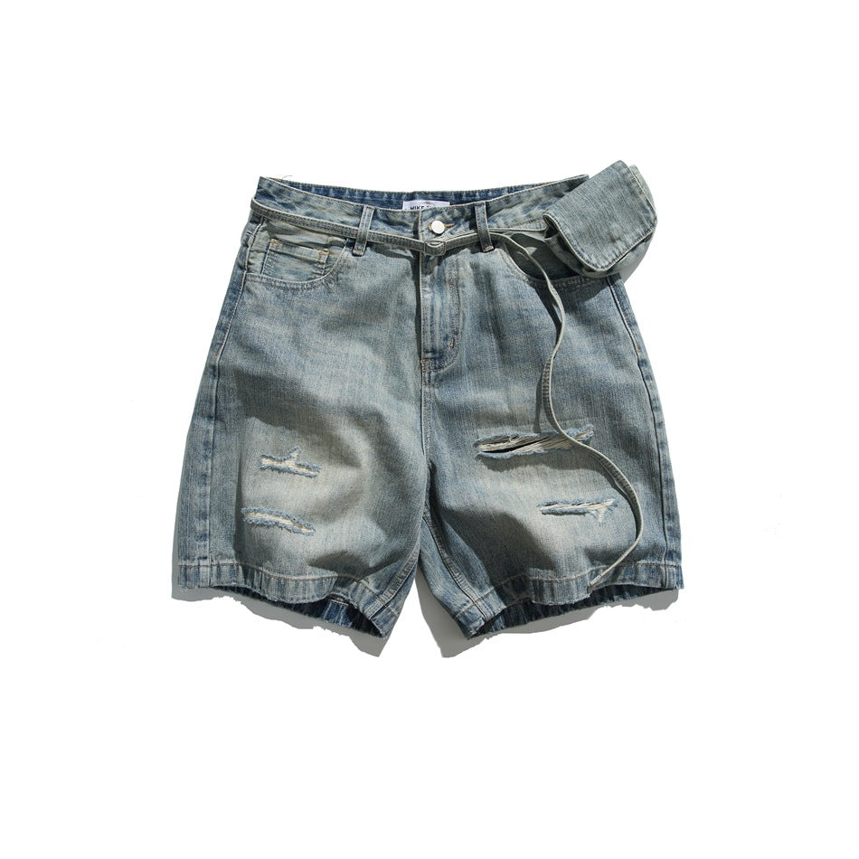 Flat lay of faded blue ripped denim shorts with a thin fabric belt and small pouch, front view