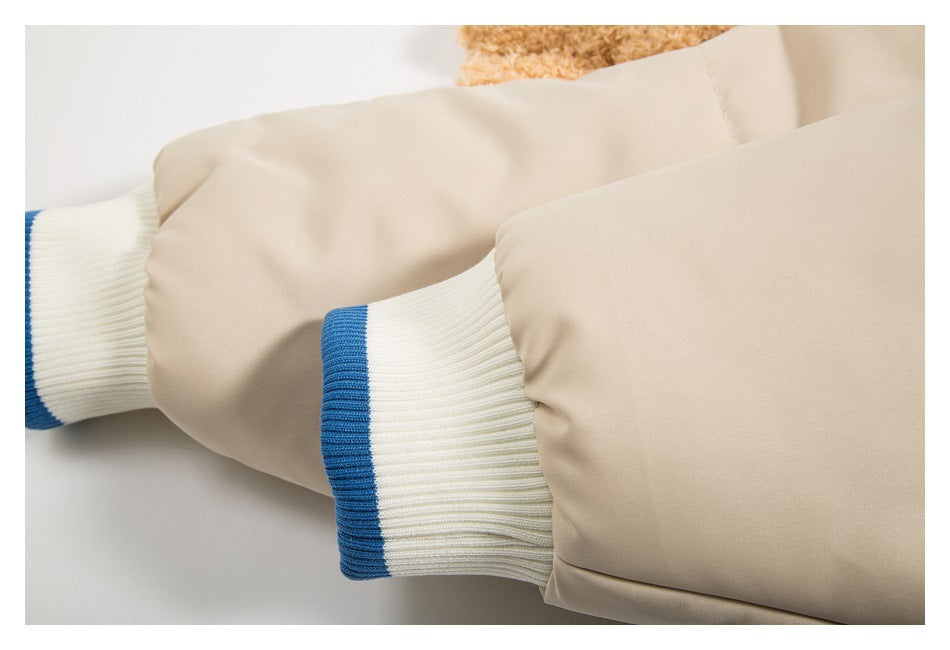 Close-up of beige jacket sleeves with white ribbed cuffs finished with blue bands.