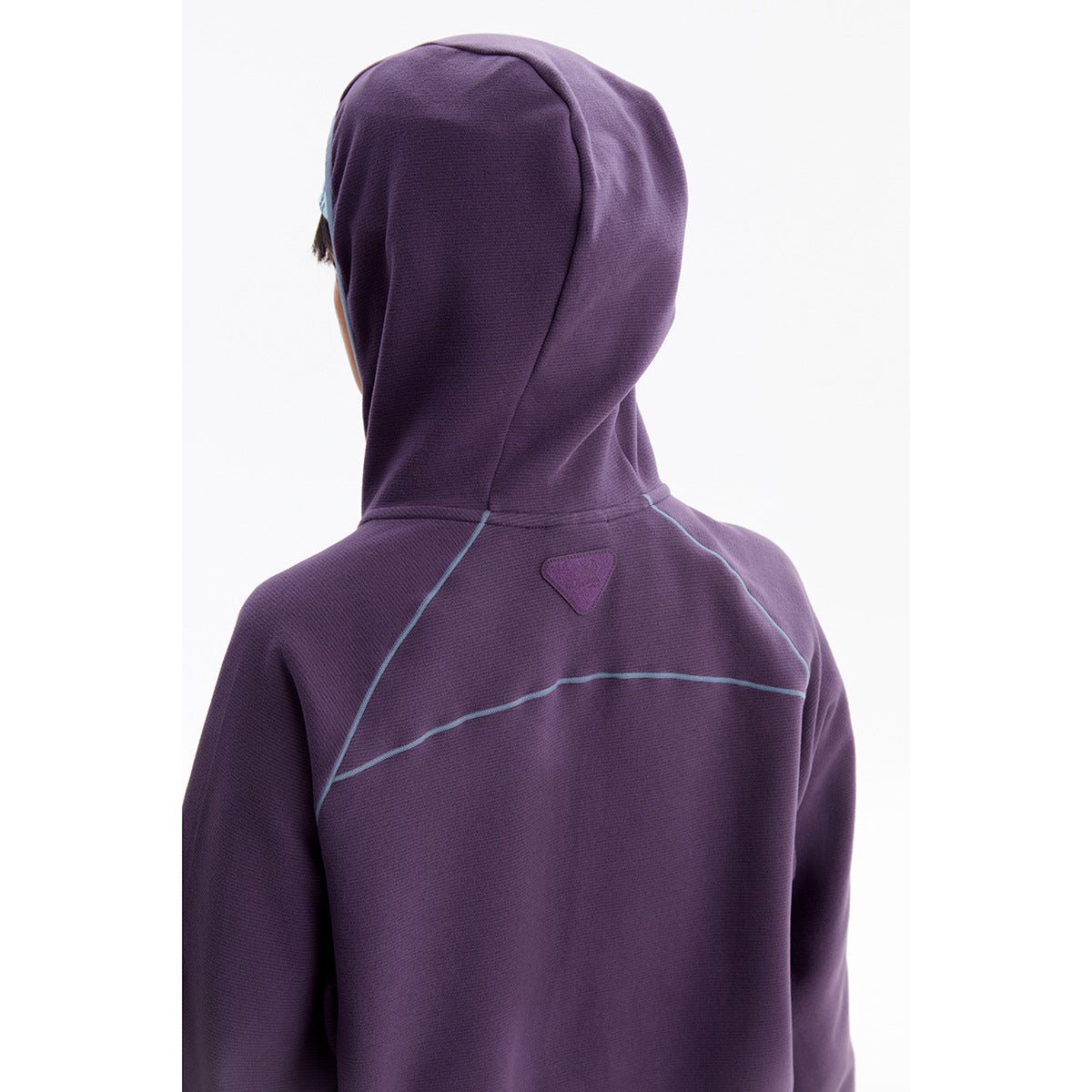 Rear view of a purple hooded jacket showing blue seam piping and a small patch high on the back.