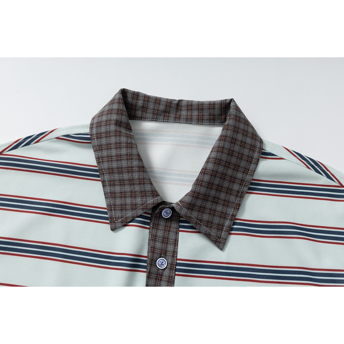 Close-up of a pale mint polo shirt with navy and red stripes, brown plaid collar, and matching button placket.
