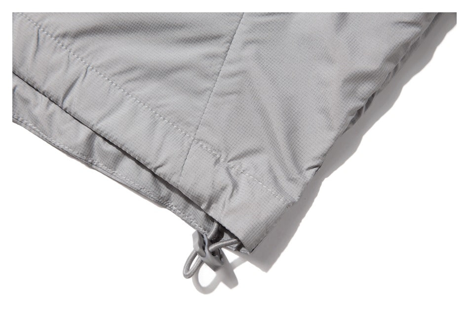 Close-up of the light gray jacket hem with an adjustable drawcord toggle.