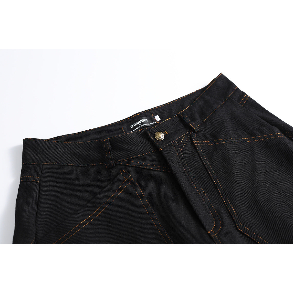 Close-up of black jeans showing the waistband, front button, belt loops, and orange stitching.