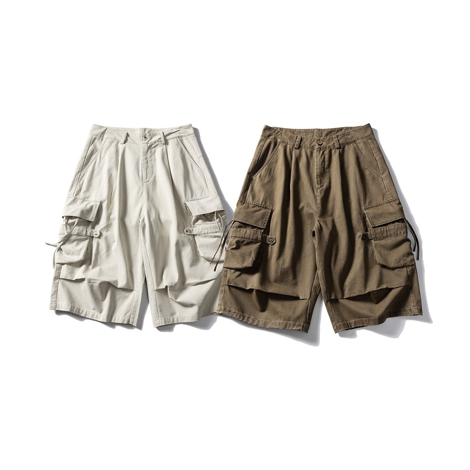 Front view of cargo shorts in off-white and khaki brown, with large flap pockets and adjustable side straps.