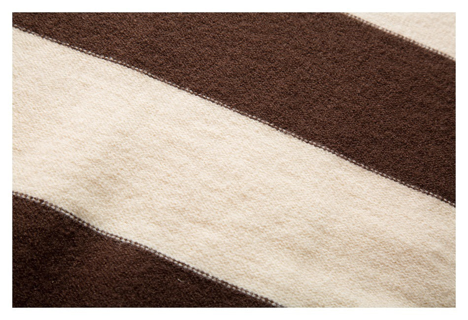 Close-up of a wide cream stripe across dark brown knit fabric.
