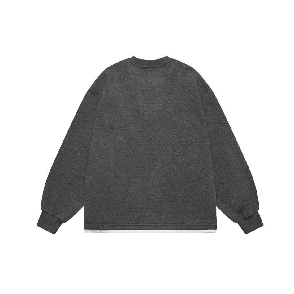 Back view of a charcoal long-sleeve sweatshirt with ribbed cuffs and a white layer peeking below the hem.