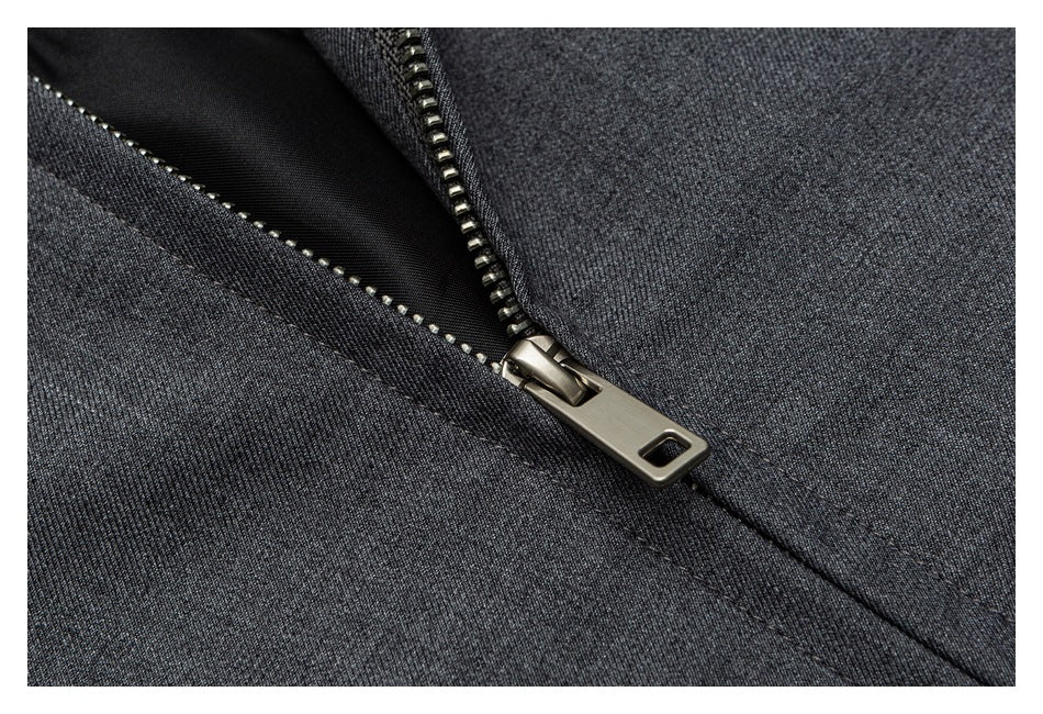 Close-up of a metal zipper and stitching on dark charcoal fabric.