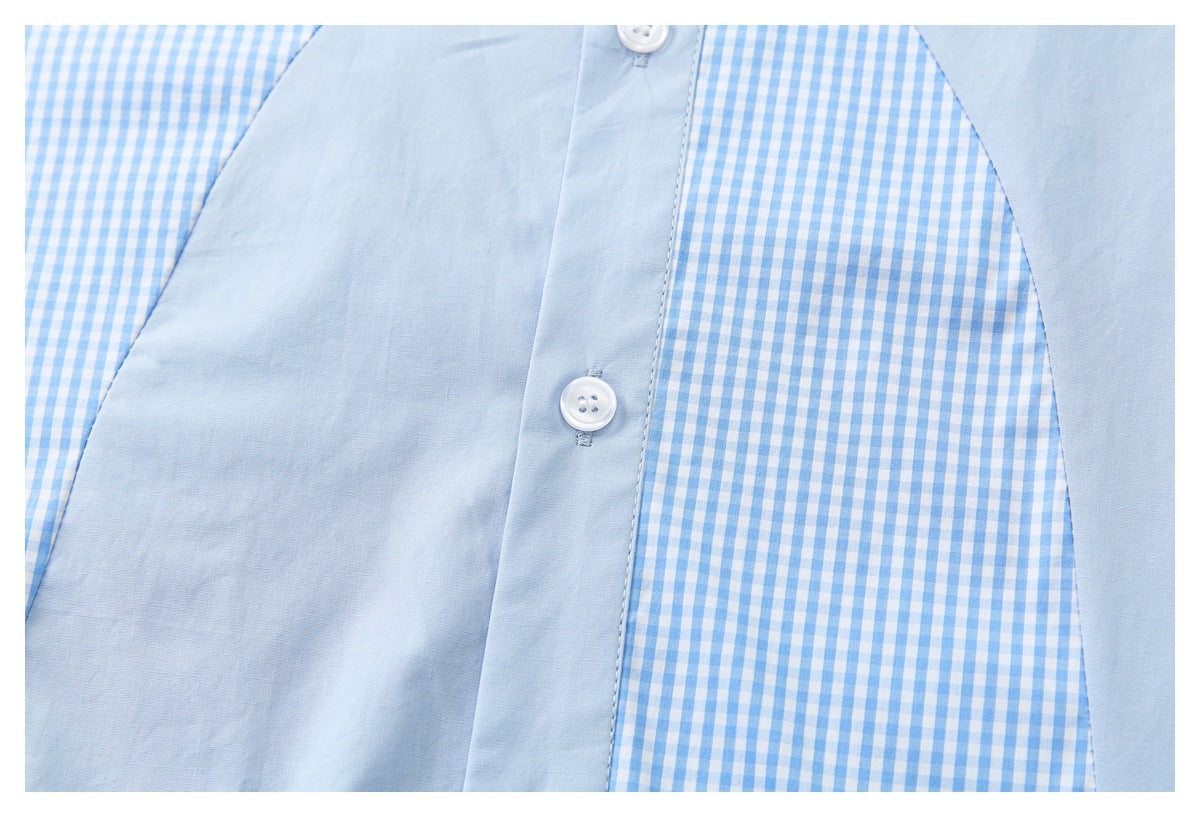 Close-up of a pale blue shirt front with white buttons and blue-and-white gingham panels.