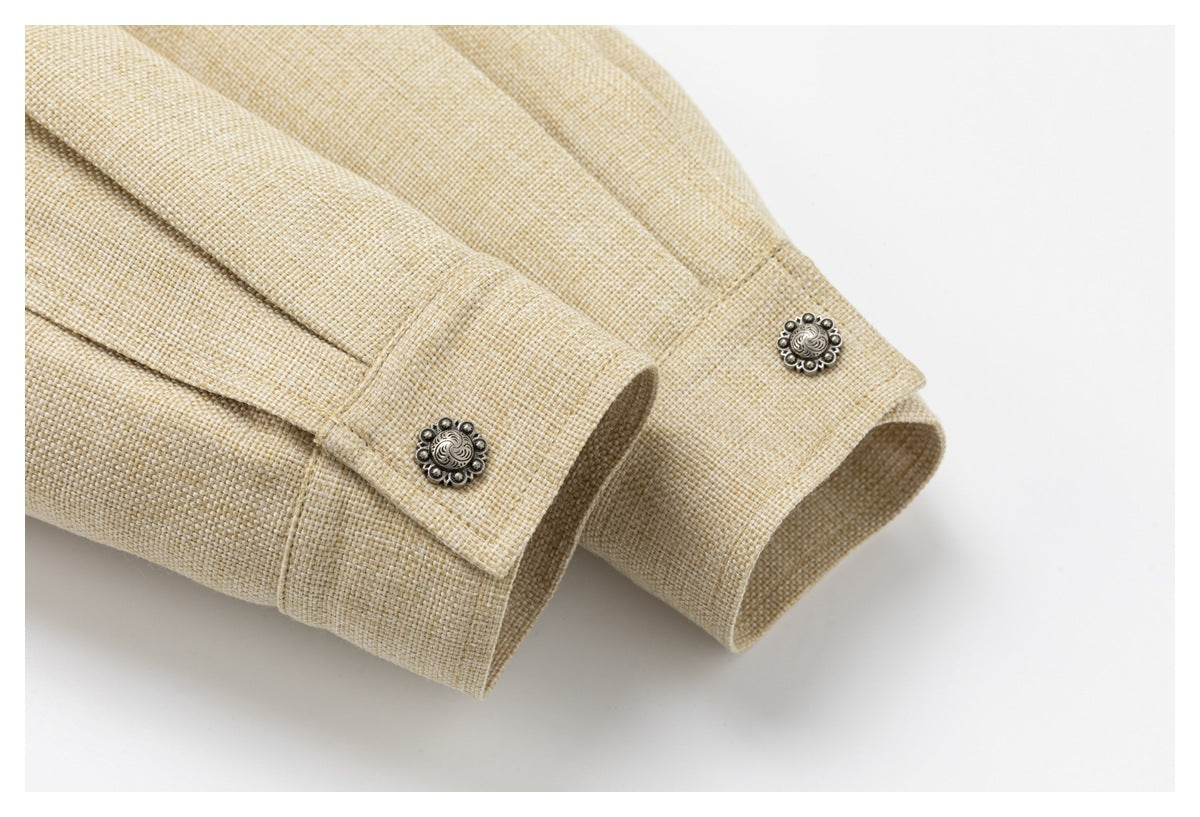 Close-up of beige jacket cuffs with ornate silver-tone buttons and visible woven texture.