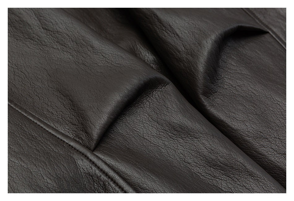Close-up of dark brown leather-look jacket panels, showing a seam and folded edge.