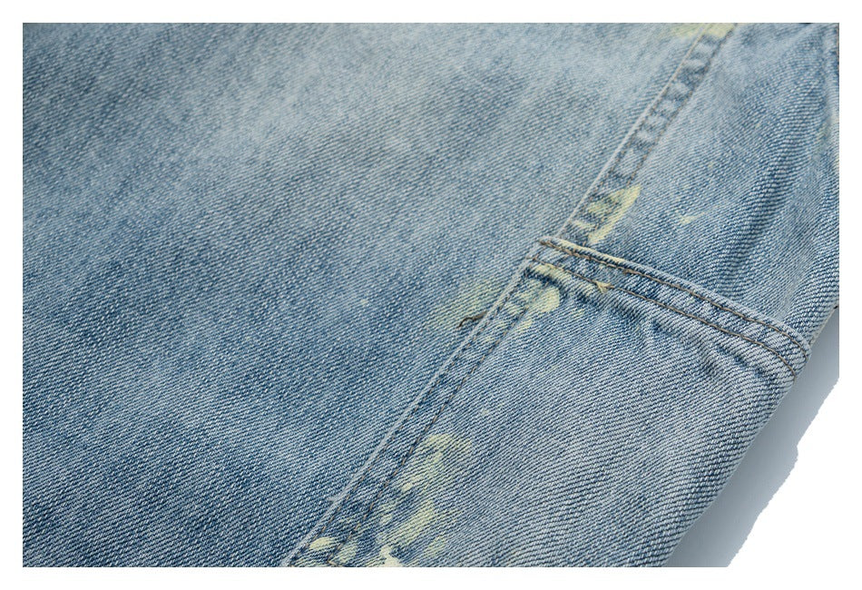 Close-up of light blue denim seams and pale distressed marks.
