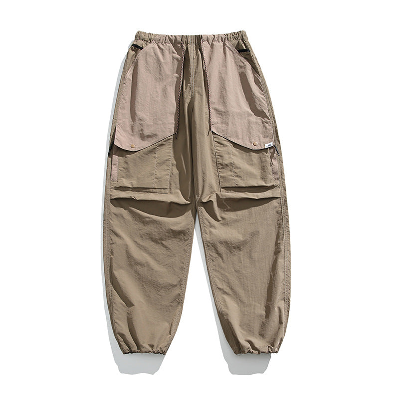 Khaki cargo pants flat lay with taupe upper pocket panels, drawstring waist, snap flap pockets and gathered hems