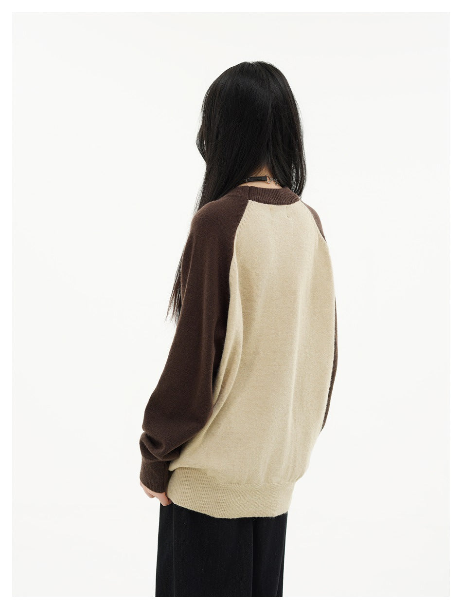 Back view of a model wearing a cream sweater with dark brown raglan sleeves and ribbed trim.