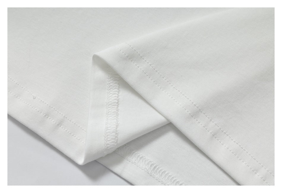 Close-up of white garment seams, showing stitching and an overlocked edge.