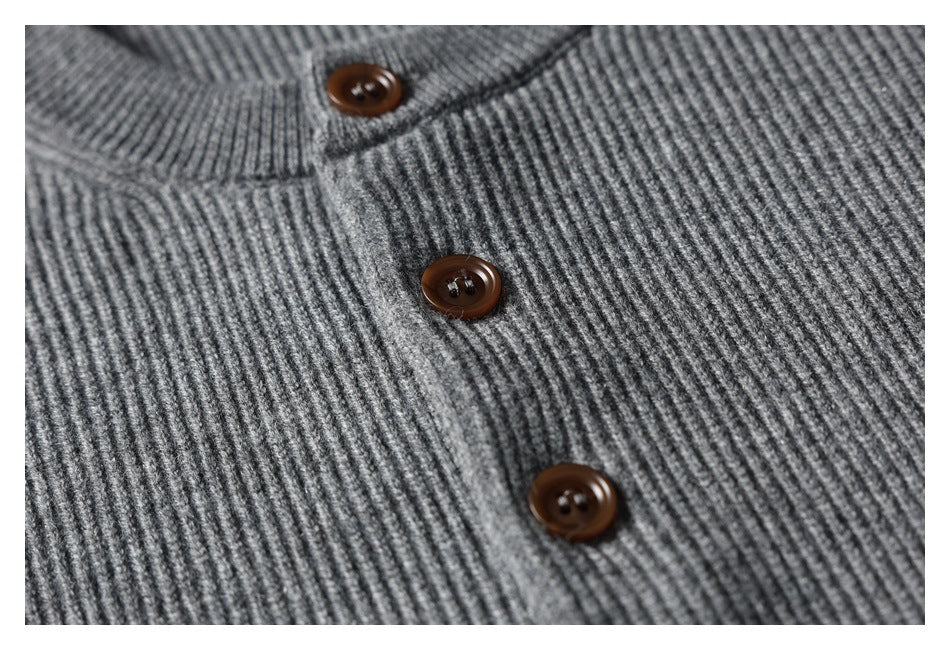 Close-up of a gray rib-knit cardigan placket with three brown buttons.