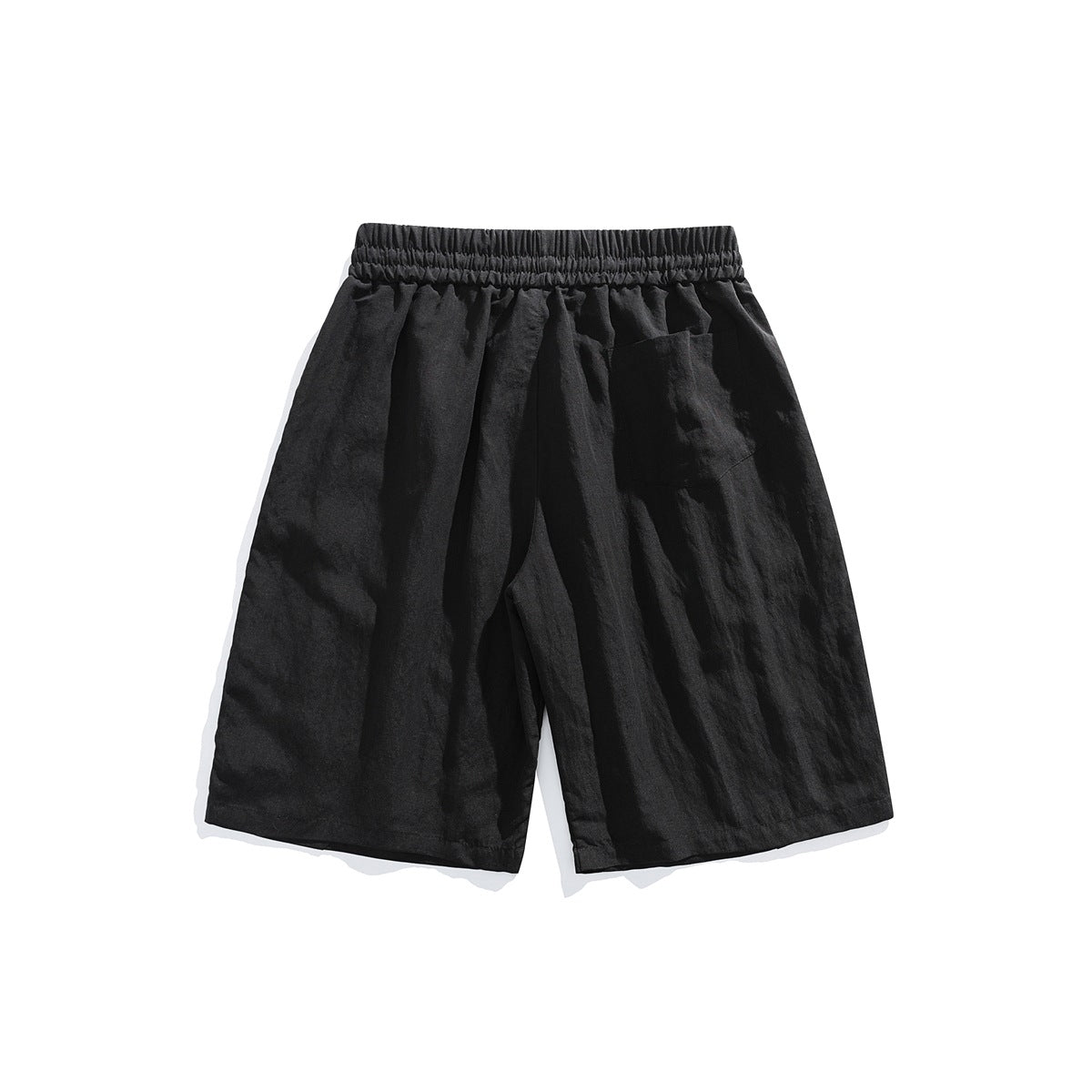 Back view of black loose-fit shorts with an elastic waistband and a patch pocket.