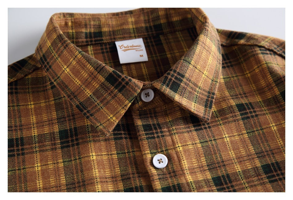 Close-up of the plaid shirt’s pointed collar, top buttons, and small inside-neck label.