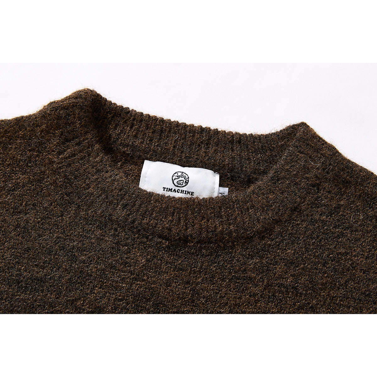 Close-up of a brown knit sweater neckline with a white TIMACHINE label.