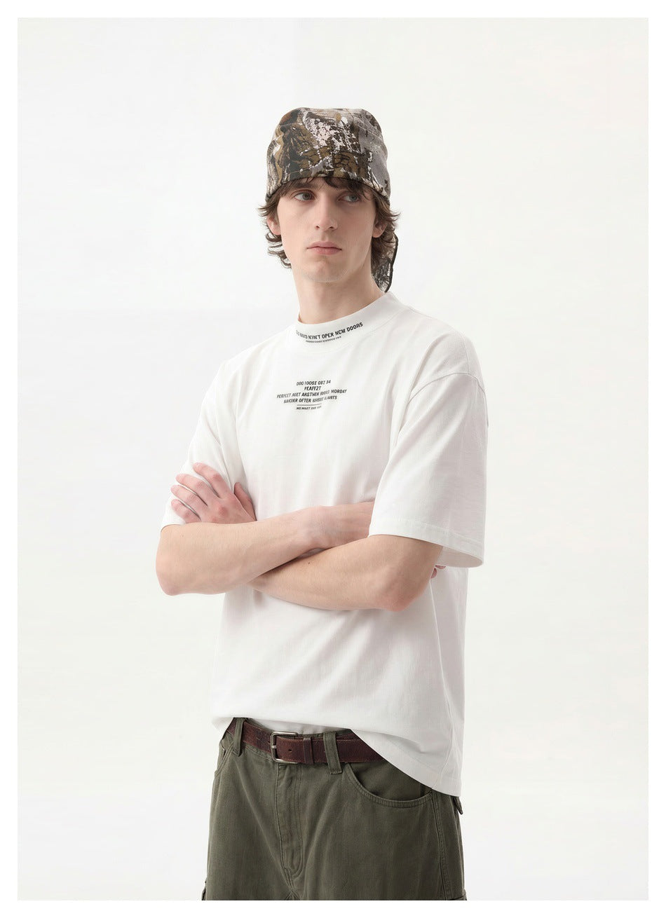 Model in a white short-sleeve T-shirt with small black chest lettering and olive cargo shorts.