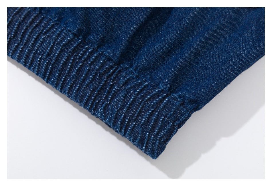 Close-up of gathered elastic at the edge of dark indigo denim.