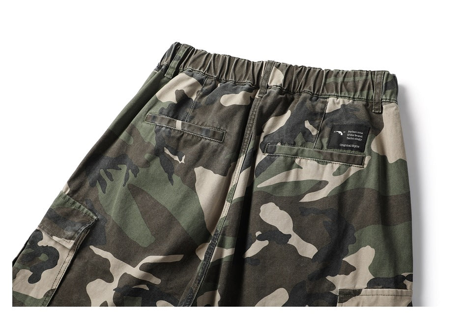 Rear upper section of camouflage cargo pants, showing an elastic waist, belt loops, and back pockets.