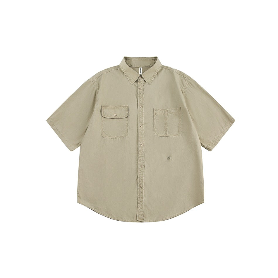 Khaki short-sleeve button-up work shirt flat lay with flap and patch chest pockets and curved hem